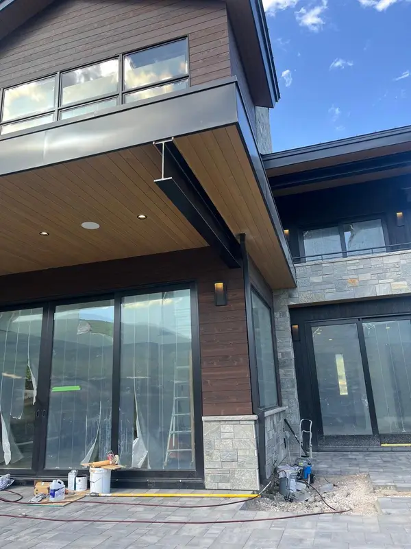 Modern home facade with large windows and a wood soffit, a job by The HANDYMAN