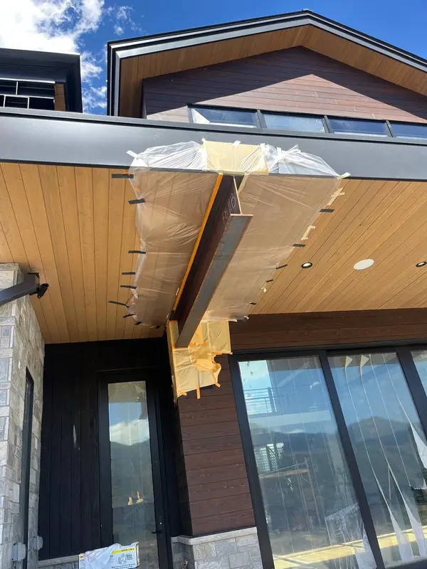 Exterior wood soffit in progress, protected with plastic